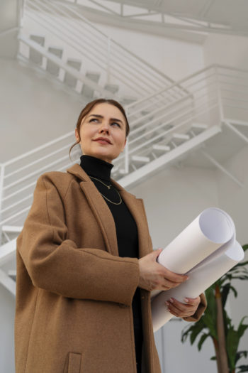 Image d'une femme architecte qui tient des plans